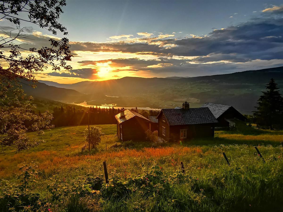 Solnedgang med noen hus i front  - Klikk for stort bilde